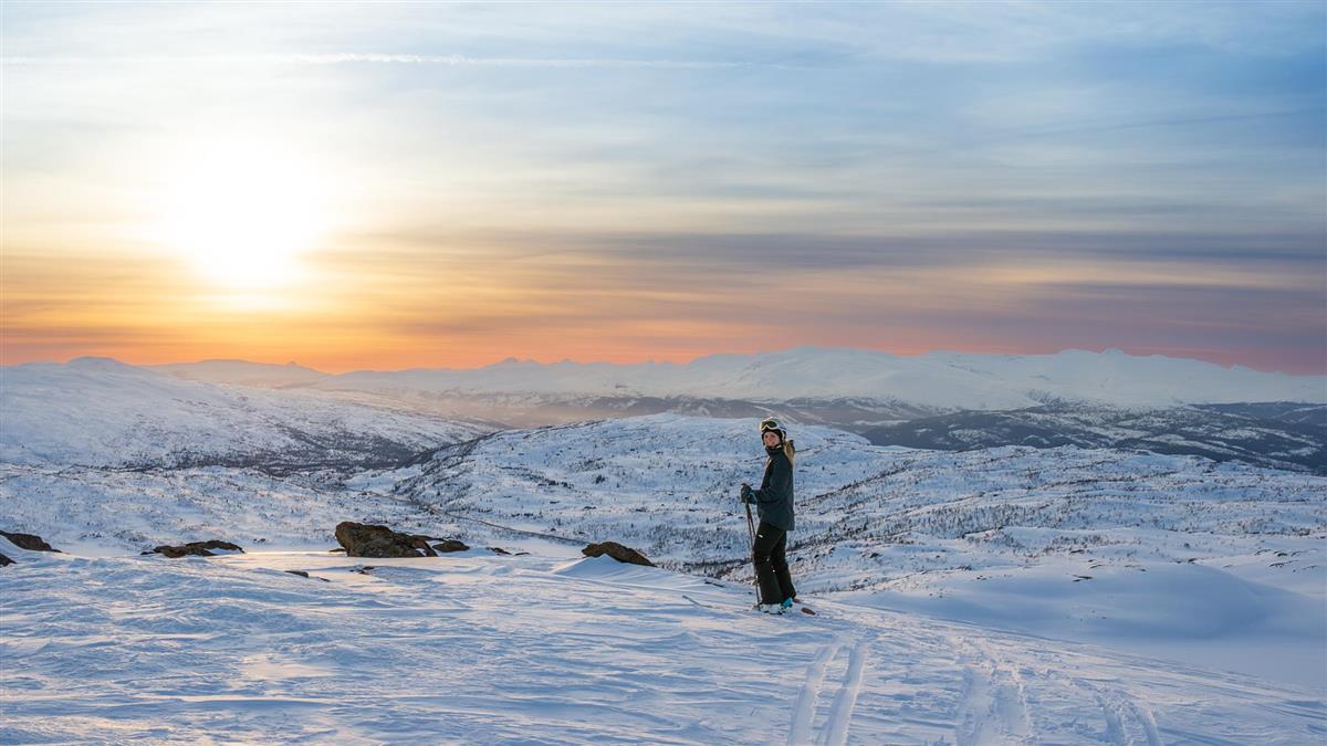 En kvinne går på ski i et fjellandskap.  - Klikk for stort bilde