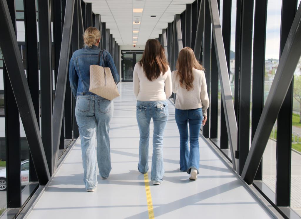 Tre studenter går i en korridor. - Klikk for stort bilde