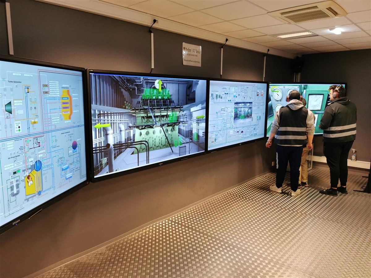 To studenter i en maskinsimulator. - Klikk for stort bilde